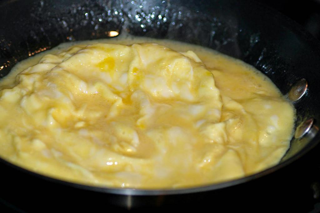 wie zu Kochen ein Omelett aus den Eiern in der Pfanne
