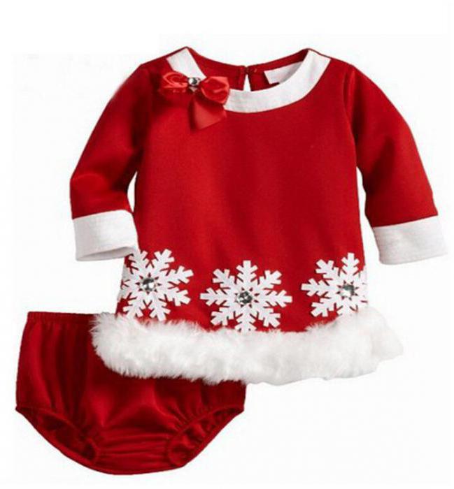 縫うようにクリスマスの衣装のための子供の手の