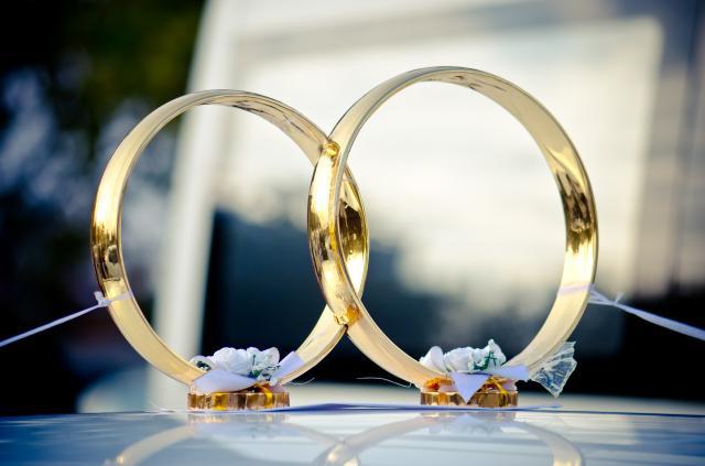 Hochzeit Ringe auf dem Auto mit Ihren Händen