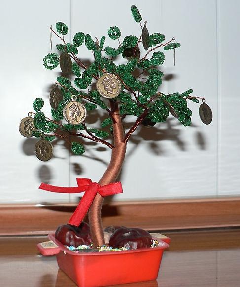 Geld-Baum mit seinen Händen von Münzen